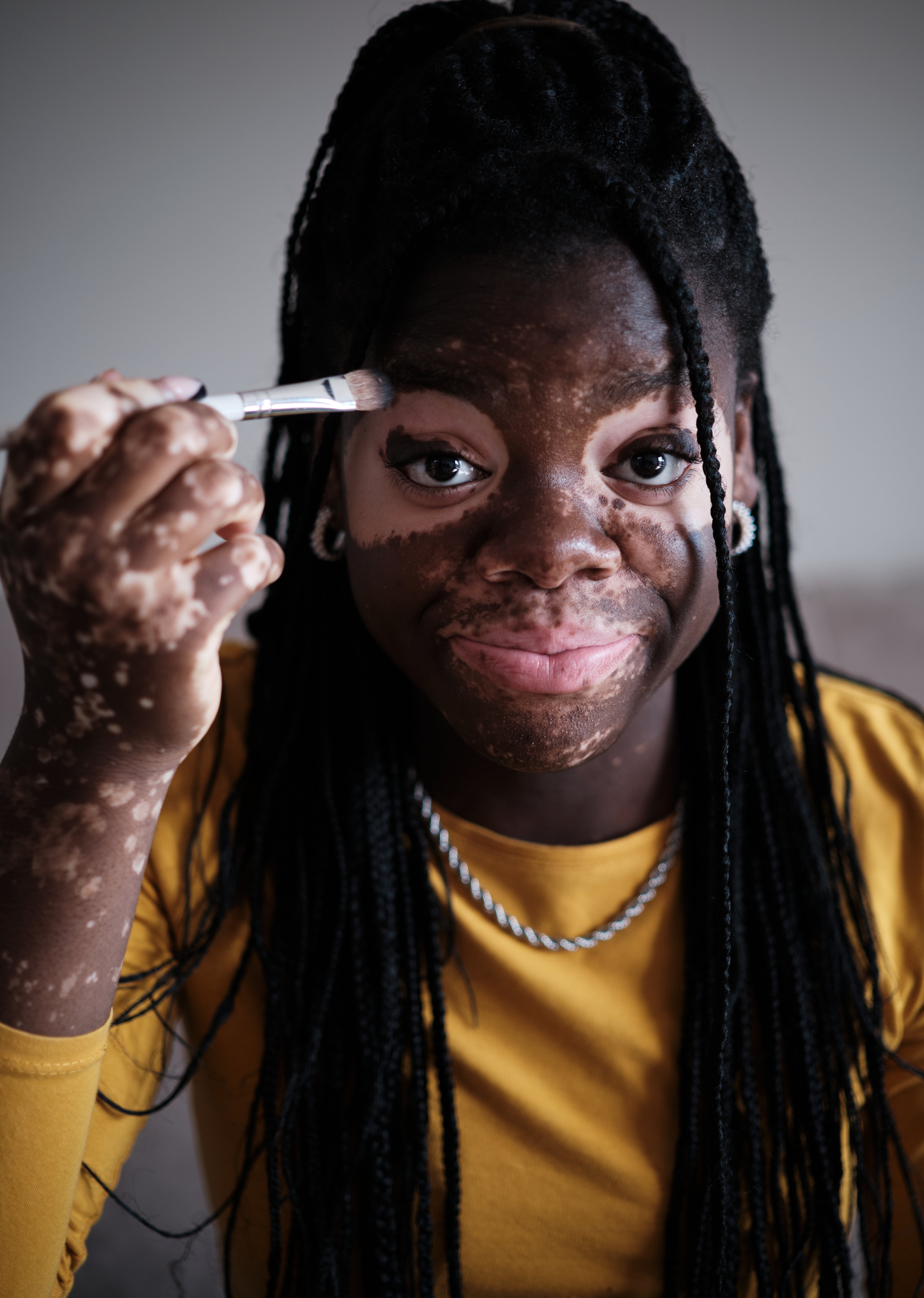 smiling-black-woman-with-vitiligo-doing-makeup-wit-2025-03-09-07-06-07-utc.jpg
